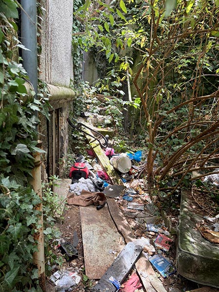 Passage extérieur très encombré avant évacuation des déchets et objets
