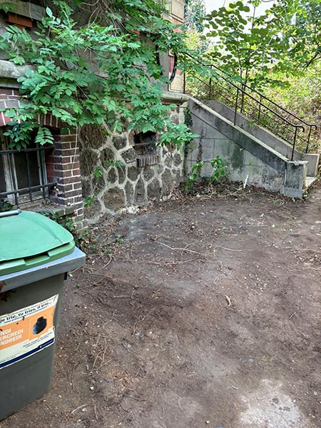 Zone extérieure de maison débarrassée après évacuation des objets accumulés