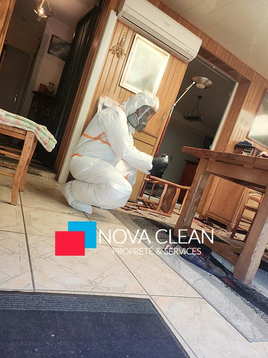 Technicien Nova Clean équipé d'une combinaison et d'un masque lors d'un nettoyage après décès