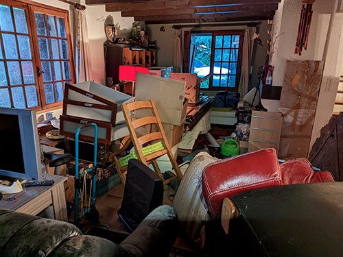 Salon très encombré de mobilier avant une intervention de nettoyage après syndrome de Diogène