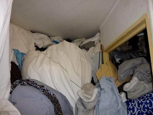 Couloir difficilement accessible en raison d'une forte accumulation d'objets dans un logement Diogène
