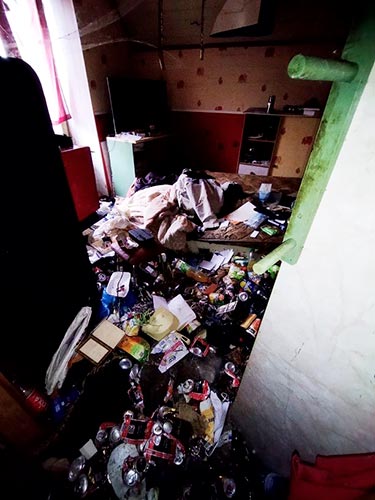 Cuisine encombrée de déchets et d'objets avant débarras et nettoyage d'un logement Diogène