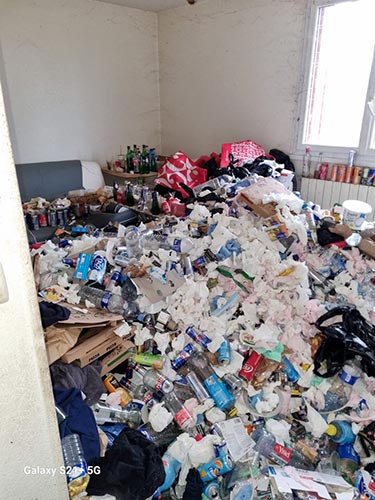 Pièce à vivre encombrée de déchets et d'objets avant débarras et remise en état d'un logement Diogène